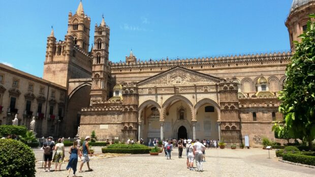 The Palermo cathedral architecture is admired by many tourists on a sunny day