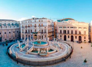 Historic architecture in Palermo with beautiful fountain and clear blue sky