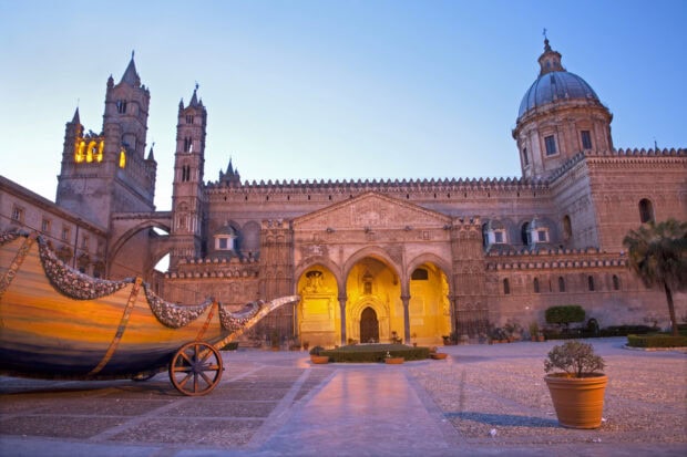 Historic architecture of Palermo Cathedral in Sicily during sunset with decorative boat display
