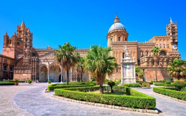 Historic Palermo architecture with green gardens under clear blue sky
