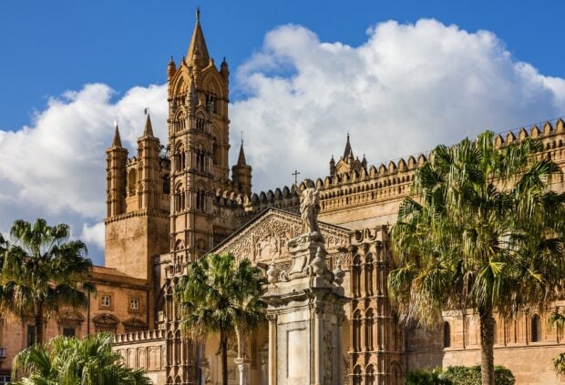 Historic Palermo architecture with palm trees under a blue sky