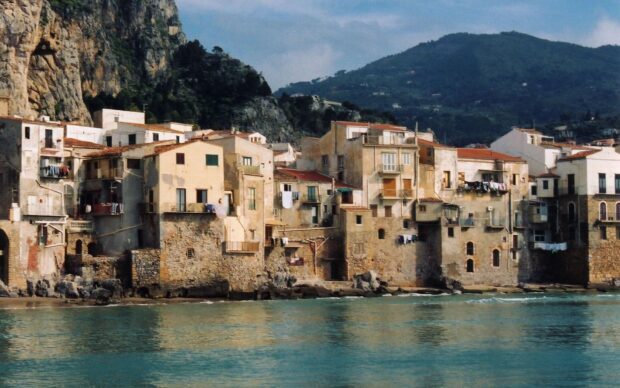 Historic Palermo town buildings by the sea with mountains in the background