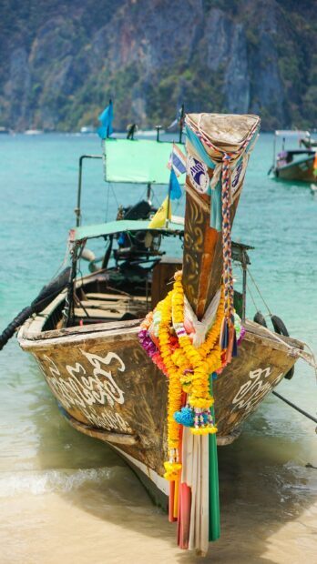 Traditional Thai longtail boat decorated with yellow garlands in Phi Phi