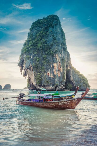 Traditional wooden boat near a limestone cliff in Phi Phi