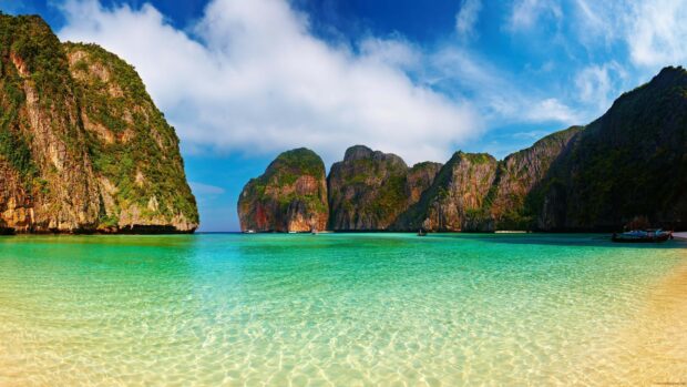 Clear turquoise water and rocky cliffs at Phi Phi islands with a bright sky