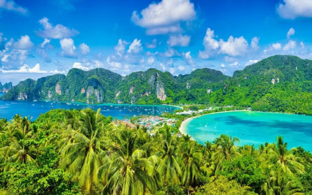 Lush green Phi Phi islands with tropical trees and turquoise blue sea under a bright sky
