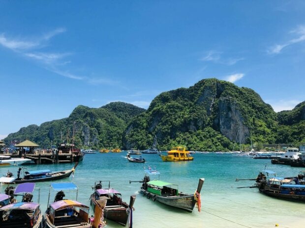 Traditional boats docked near lush green cliffs in Phi Phi waters