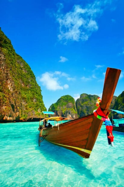 Traditional wooden boat floating on clear turquoise water at Phi Phi