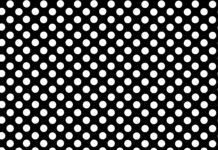 A black polka dot pattern with evenly spaced white dots on a smooth surface