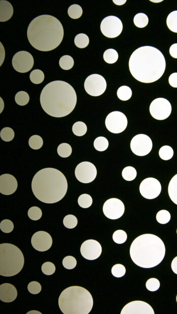 Bright polka dot pattern with various sizes on a dark background