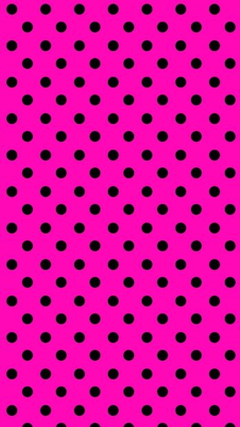 A bright pink pattern decorated with evenly spaced black polka dot designs