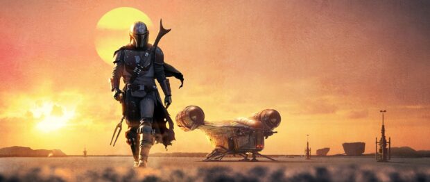 Mandalorian character walking on desert planet with futuristic ship at sunset