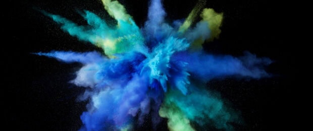 Vibrant powder explosion with blue and green colors on black background