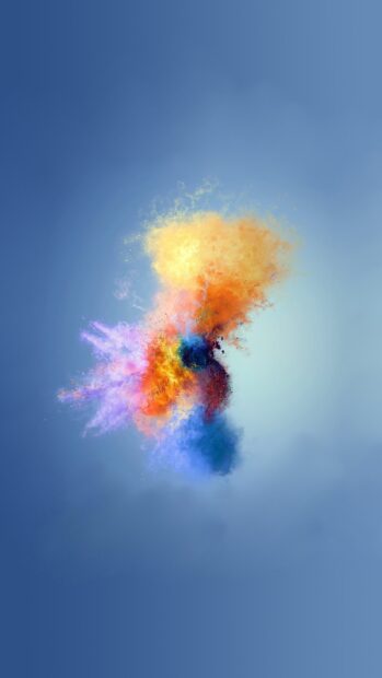 Vibrant multicolored powder explosion with orange blue and purple hues on a soft blue background