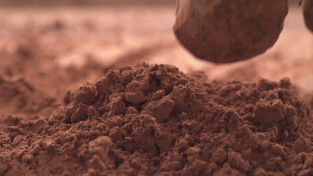 Brown powder texture close up with clumpy details and soft focus background