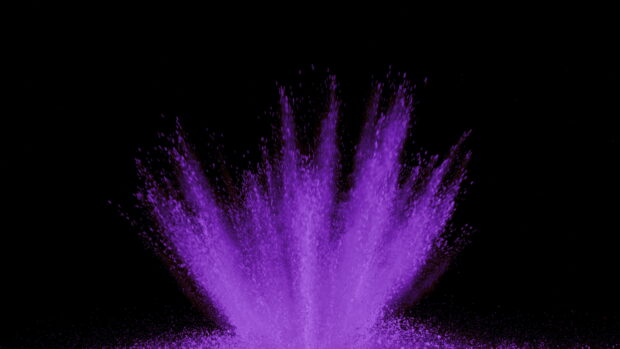 Purple powder explosion captured in motion on a black background with vibrant color powder