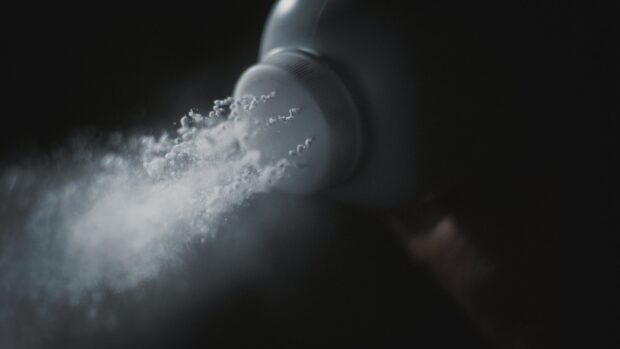 White powder flowing from container in dark setting