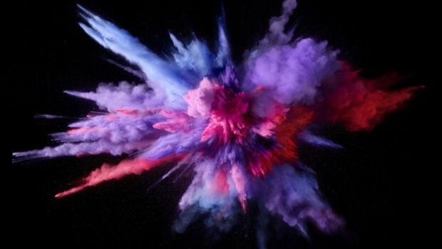 Colorful powder explosion captured in midair with vibrant shades of purple and red powder