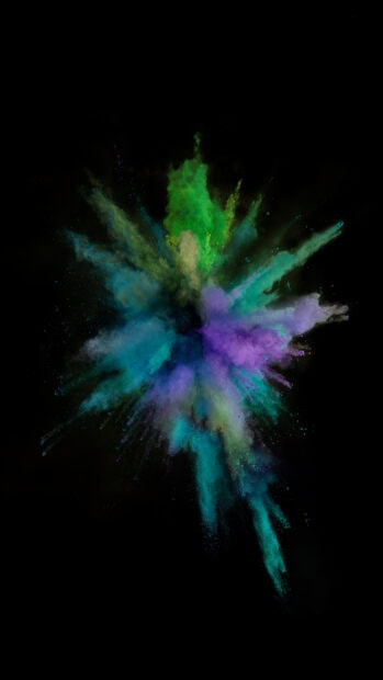 Vibrant green and purple powder explosion with blue hues on black background