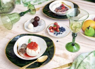 A creamy pudding topped with fruit sauce and chocolate truffles on a decorative plate