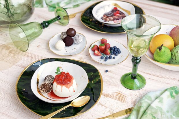 A creamy pudding topped with fruit sauce and chocolate truffles on a decorative plate
