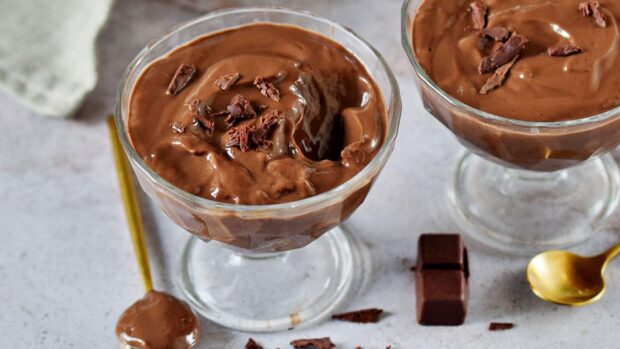 Creamy chocolate pudding topped with chocolate shavings in glass cups