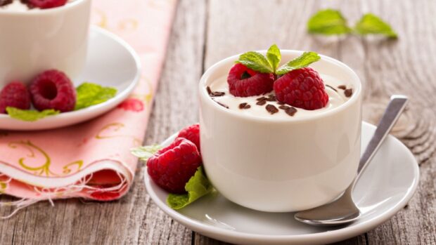 A delicious pudding dessert topped with fresh raspberries and mint leaves
