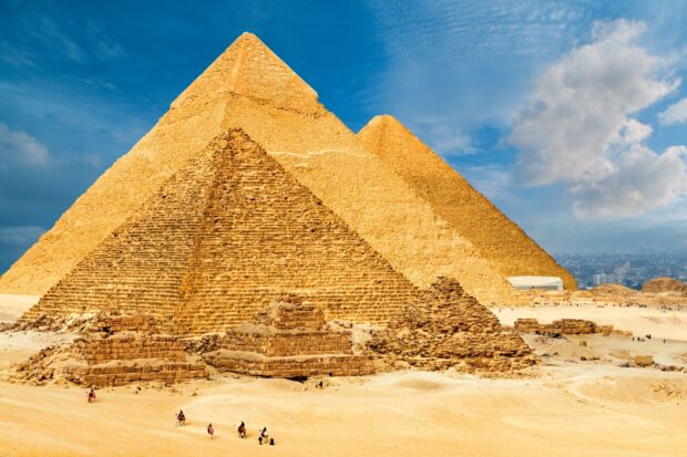 Ancient pyramids of Giza standing majestically under a bright blue sky with scattered clouds