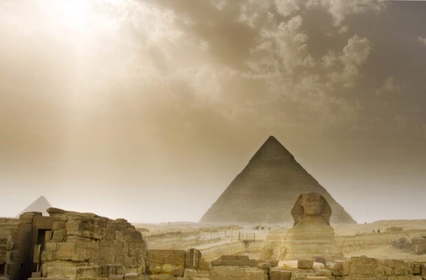 The Great Sphinx and ancient pyramids of Giza under a cloudy sky in Egypt
