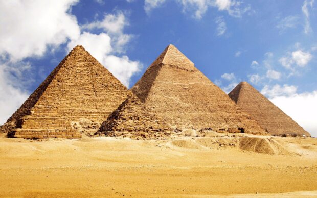The ancient pyramids of Giza standing tall under a bright blue sky