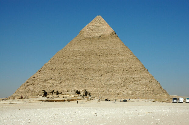 The Great Pyramid of Giza standing tall under a clear blue sky in the desert