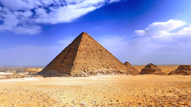 The ancient pyramids of Giza standing prominently in the Egyptian desert under a bright blue sky