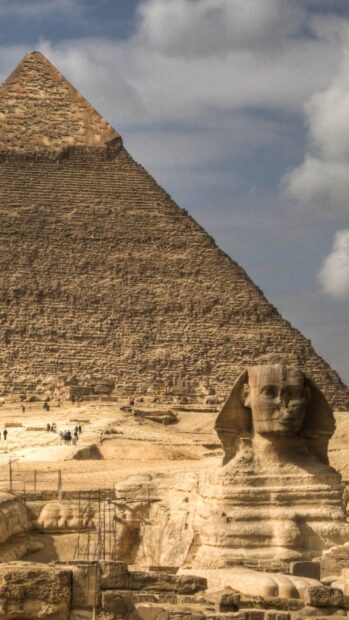 The Great Sphinx and one of the pyramids in Giza under a cloudy sky