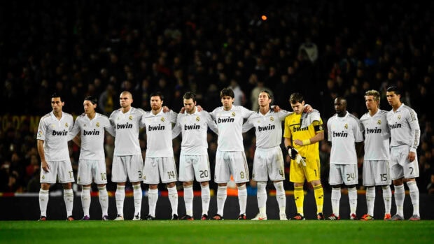 Real Madrid Cf players standing together on the field before a match in their white kits