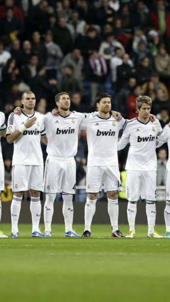 Real Madrid Cf players standing together on the field during a match
