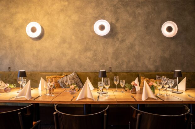 Elegant restaurant setting with neatly arranged tables and decorative cushions on a cozy seating area