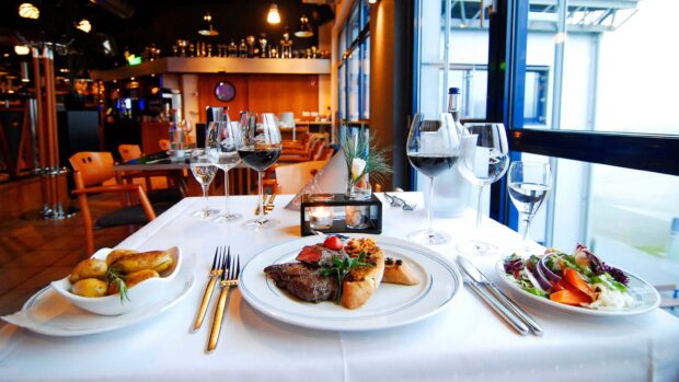 A fine dining setup with steak and salad in a restaurant setting