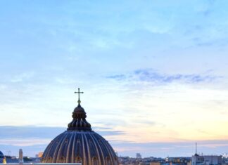 Elegant rooftop dining area with restaurant setup and cityscape in evening light