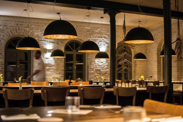 A restaurant interior with wooden chairs and hanging lamps creating a cozy restaurant atmosphere