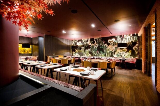 Modern restaurant interior with restaurant tables and floral wall decor