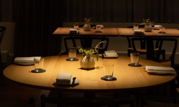 A restaurant table setting with glasses and napkins in a cozy dining area