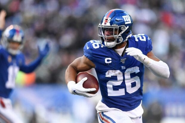 Saquon Barkley running with the football during an NFL game in a blue uniform