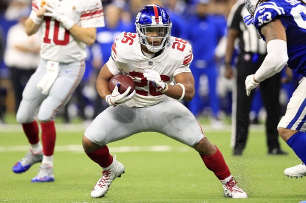 Saquon Barkley running with the football during an NFL game on the field