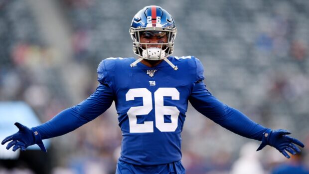 Saquon Barkley stands confidently with arms open wearing his blue New York Giants uniform