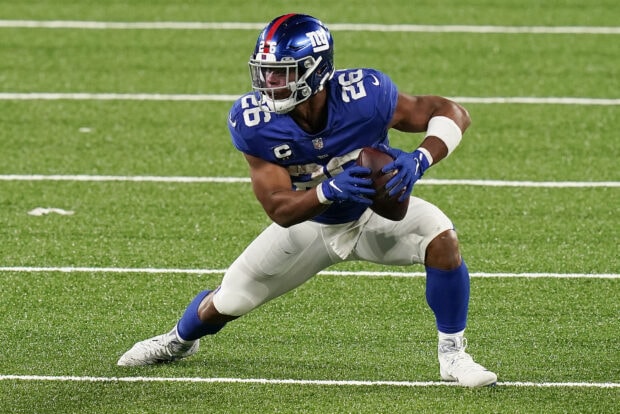 Saquon Barkley holding a football and preparing to make a play on the field