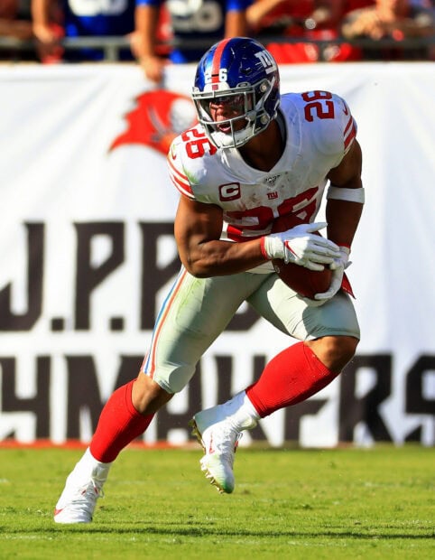 Saquon Barkley running with a football in his New York Giants uniform