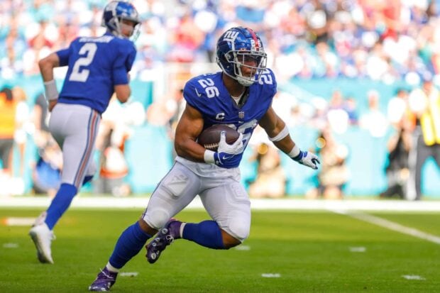 Saquon Barkley running with the football during an NFL game in a blue jersey
