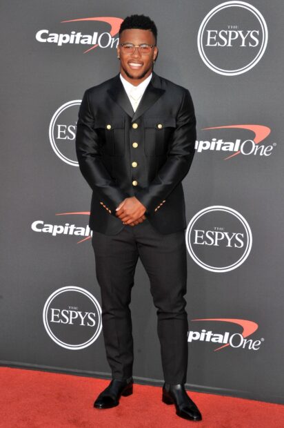 Saquon Barkley wearing a black suit at an event on the red carpet