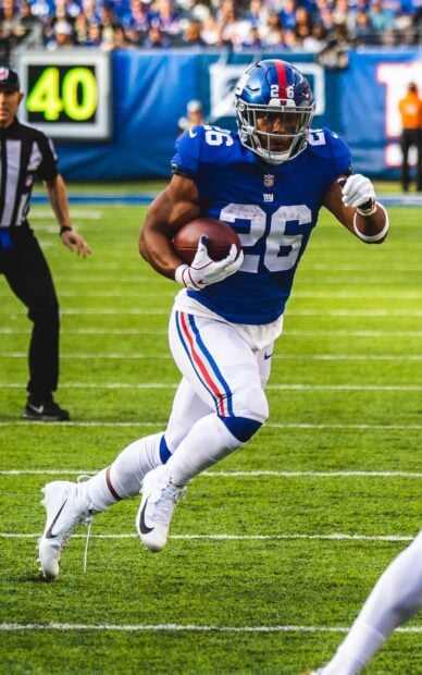 Saquon Barkley running with the football during a game on the field
