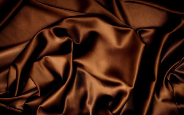 Smooth brown satin fabric with elegant folds and soft shining texture